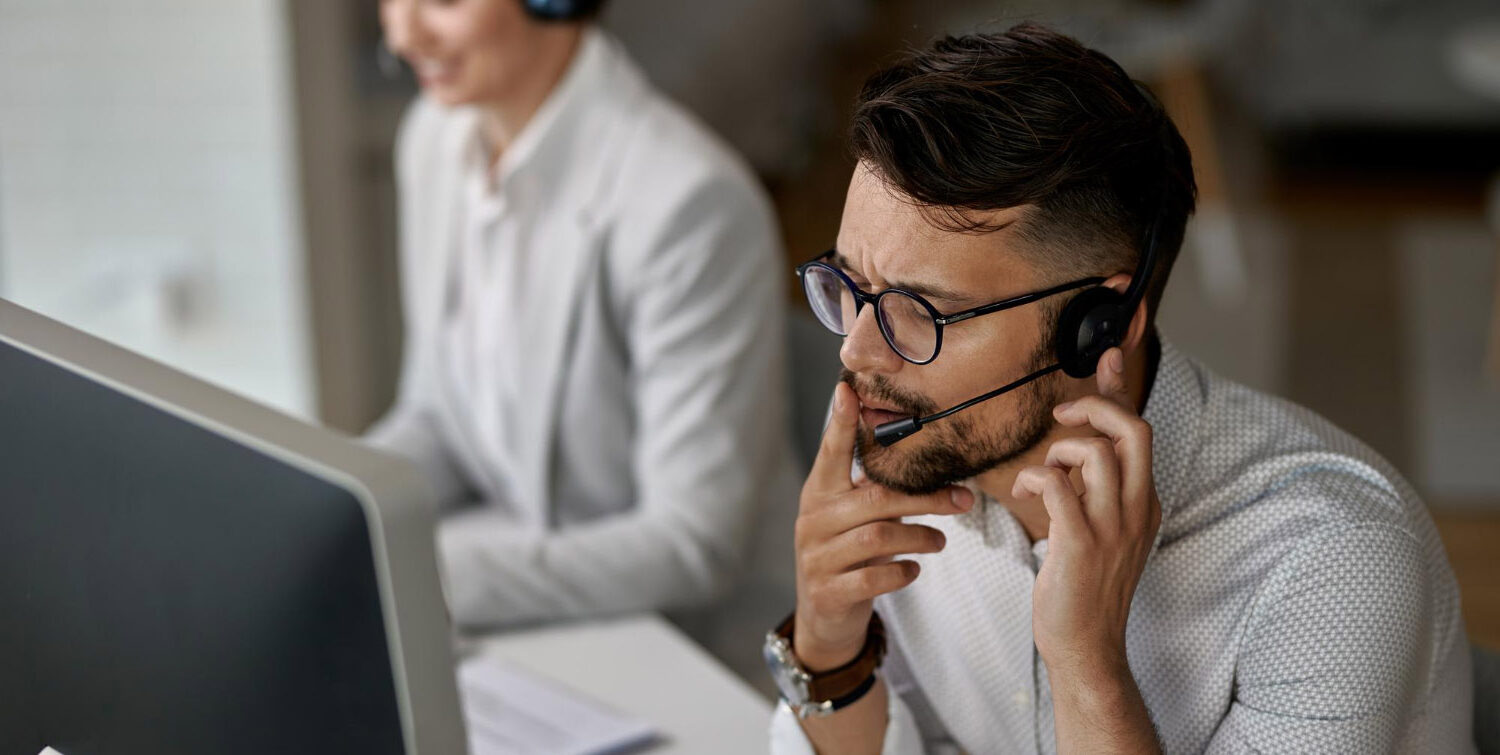 Agent concentré parlant client tout travaillant au bureau